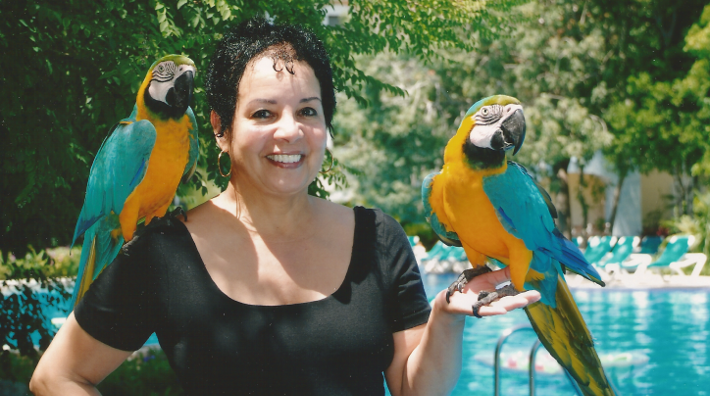 Carmen posing with a pair of toucans.